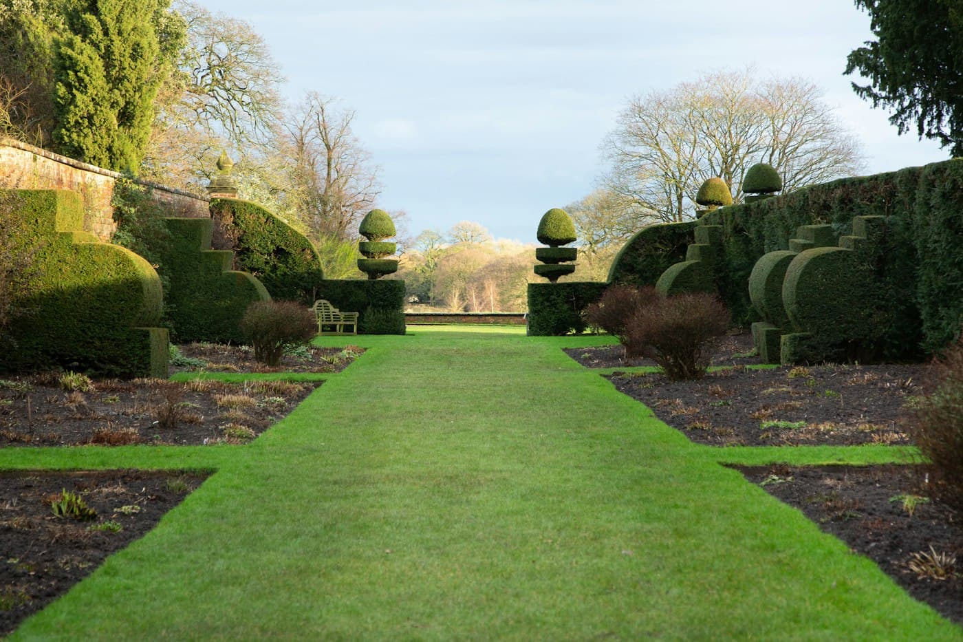 Manicured lawn framed by clipped hedges and topiary