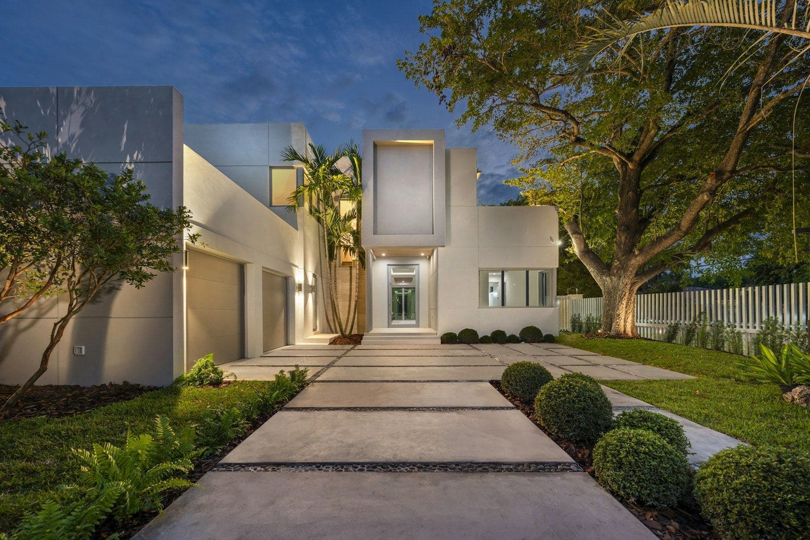Modern home with an illuminated garden pathway at dusk
